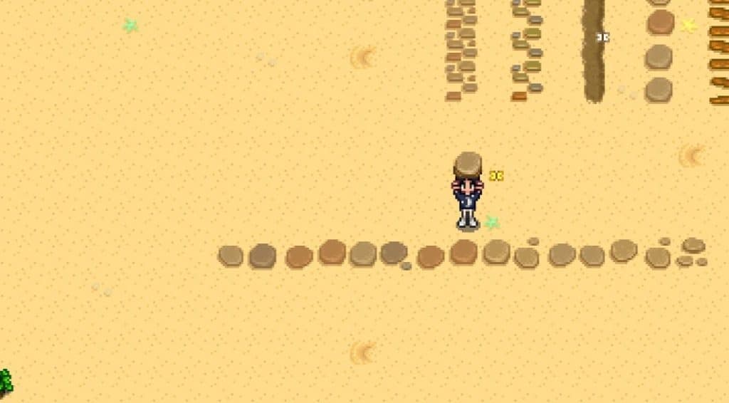 Stepping stone path in a blanket of yellow sand, with the player standing above it.