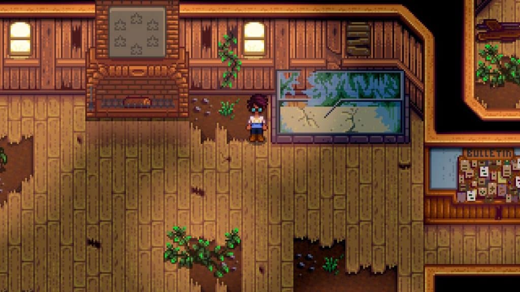 The player standing near the Fish Tank in Stardew Valley (Community Center) containing all fish bundles.